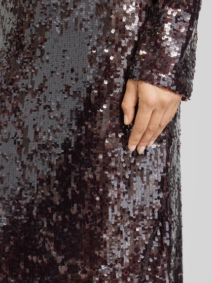 Frauenmodel trägt Midirock mit Pailletten Modell 'XJAVIERA' von Mango, Material-Mix mit Stretch-Anteil, Nahaufnahme Oberschenkel.