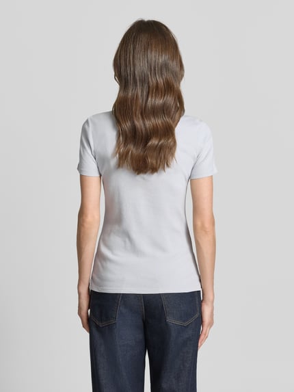 Frauenmodel trägt Regular Fit Poloshirt aus reiner Baumwolle von Tom Tailor, unifarben, kurzarm, Jersey, Ganzkörperansicht Rückansicht.