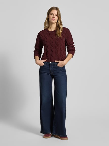 Frauenmodel trägt Regular Fit Strickpullover mit Zopfmuster Modell 'ELLY' von Only, unifarben, cropped, Rundhals, Ganzkörperansicht von vorne