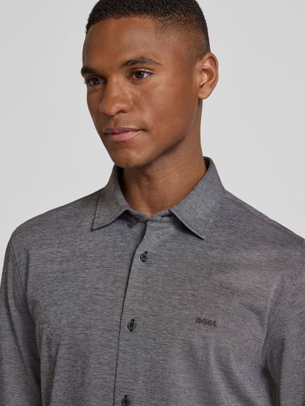 Männermodel draagt Slim Fit Freizeithemd aus reiner Baumwolle Modell 'MYSOFT_2' van BOSS Orange in grijs melange, Nahaufnahme Oberkörper.