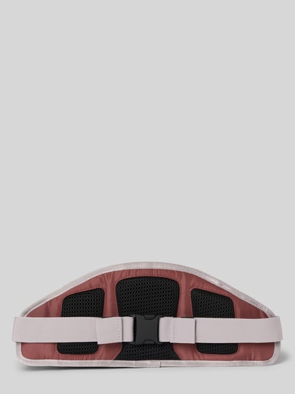 Produktfoto, Bauchtasche mit Label-Detail von PEAK PERFORMANCE, Hauptfach mit Reißverschluss, verstellbarer Riemen, Nebenfach, Innenfächer, Maße 41 cm Breite, 18 cm Länge, 7 cm Tiefe, Schulterriemen 65 cm, rosa und schwarz mit strukturierten Texturen.
