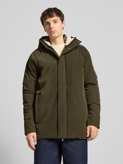 Männermodel trägt Parka mit Kapuze Modell 'WOOD' von Jack & Jones in Olivgrün, Regular Fit, verdeckter Reißverschluss, Eingrifftaschen, Ganzkörperansicht von vorne.