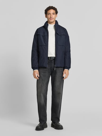 Männermodel trägt Jacke mit Stehkragen und Reißverschlusstaschen von LERROS in Dunkelblau, grobe Textur, Ganzkörperansicht von vorne, Regular Fit, Brusttaschen, Rückenlänge 60 cm, Schulterbreite 48 cm, Brustweite 58 cm, Ärmellänge 60 cm.