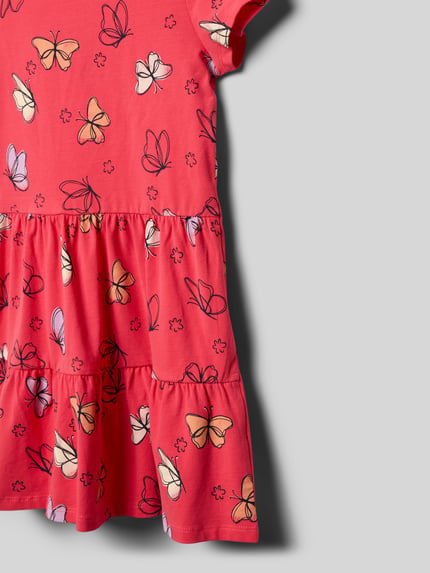 Mädchen trägt Leicht ausgestelltes Freizeitkleid aus Baumwoll-Mix von s.Oliver RED LABEL, rot mit Schmetterlingsmuster, Nahaufnahme Oberkörper.