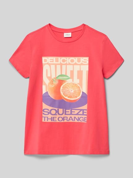Mädchen trägt Loose Fit T-Shirt aus reiner Baumwolle von s.Oliver RED LABEL in Pink mit Frontprint, unifarben, Ganzkörperansicht von vorne.