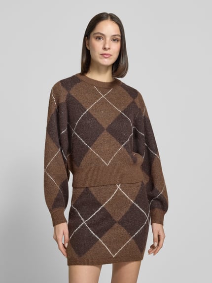 Frauenmodel trägt Pullover mit Ballonärmeln von VERO MODA, braunes Argyle-Muster, Rundhals, cropped, Strick, Ganzkörperansicht von vorne.