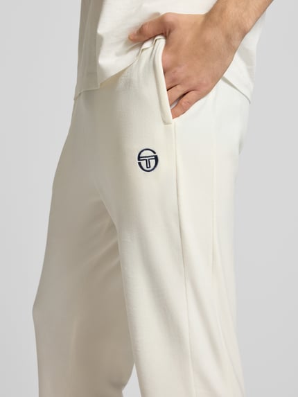 Männermodel trägt Sweatpants mit elastischem Bund von SERGIO TACCHINI in Creme, Material-Mix mit Stretch-Anteil, Label-Detail, Nahaufnahme Oberkörper.
