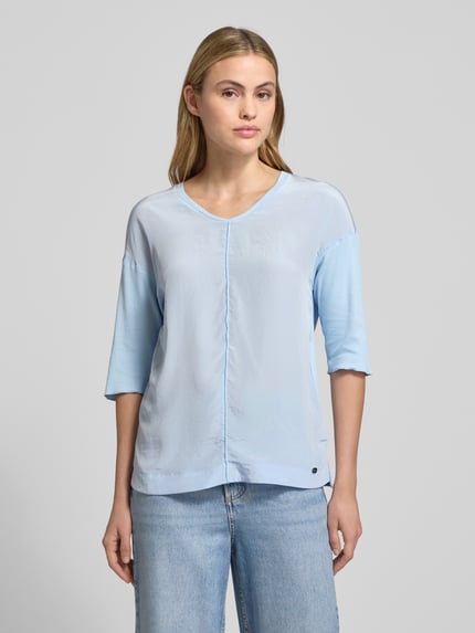 Modelka kobieca nosi T-Shirt z dekoltem V i rękawem 3/4 od Marc Cain w jasnoniebieskim kolorze, bawełna z elastanem, regular fit, widok z przodu do pasa.
