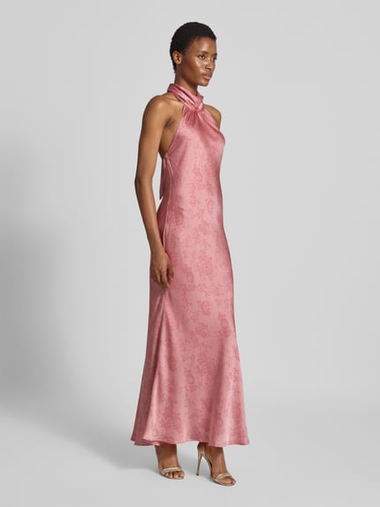 Frauenmodel trägt Abendkleid mit Neckholder Modell 'Fiona' von Neo Noir aus rosafarbenem Satin mit floraler Textur, taillierte Passform, Ganzkörperansicht von vorne