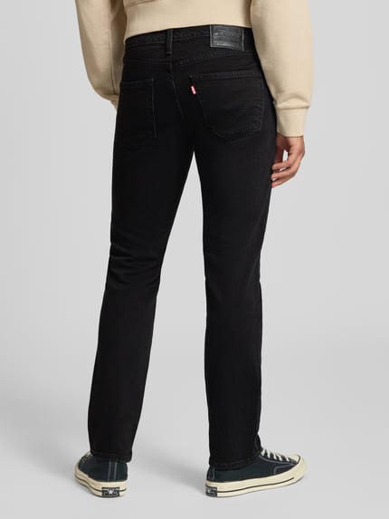 Männermodel draagt Slim Fit Jeans aus Baumwoll-Lyocell-Mix Modell '511® SLIM' van levi's®, heren slim jeans, zwarte kleur, Ganzkörperansicht Rückansicht.