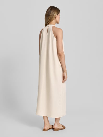 Vrouwenmodel draagt midi-jurk met mix van viscose en linnen van Someday, model 'Qelina', loose fit, lichte kleur, Ganzkörperansicht Rückansicht.