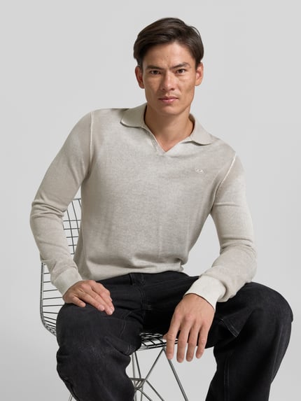 Männermodel trägt Pullover in Strick-Optik von Diesel, reine Baumwolle, Regular Fit, Used-Look, beige, gerippte Abschlüsse, Nahaufnahme Oberkörper.
