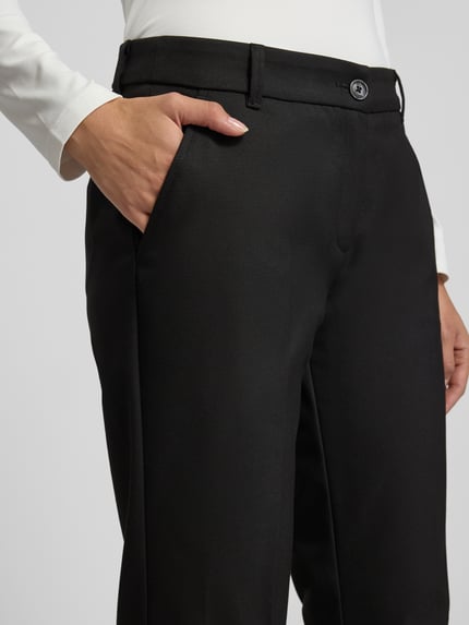 Frauenmodel trägt schwarze Straight Fit Stoffhose mit Viskose-Anteil Modell 'Maron' von Brax, Bügelfalten, Nahaufnahme Oberkörper.