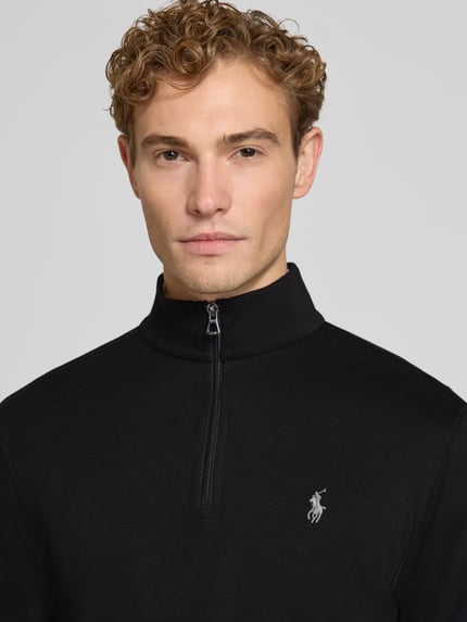 Männermodel trägt schwarzes Regular Fit Sweatshirt aus Baumwoll-Mix von Polo Ralph Lauren, dezentes Logo, glatte Textur, Nahaufnahme Oberkörper. Herren Sweatshirt von Polo Ralph Lauren