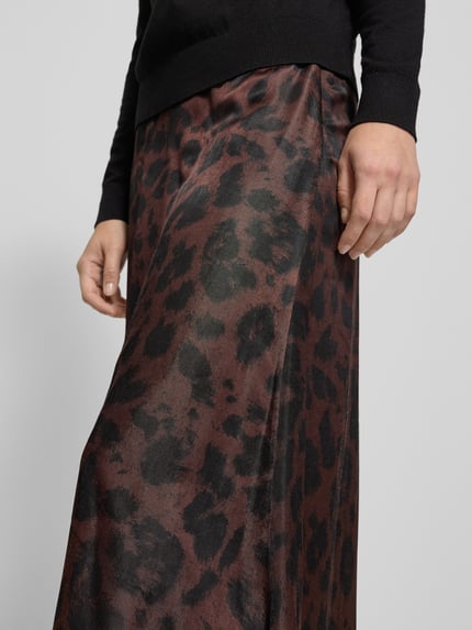 Kobieta modelka nosi Ausgestellter Midi-Rock aus Viskose-Mix od Tom Tailor w brązowo-czarny animal print, lekko rozkloszowany fason, widok z przodu, zbliżenie górnej części spódnicy.