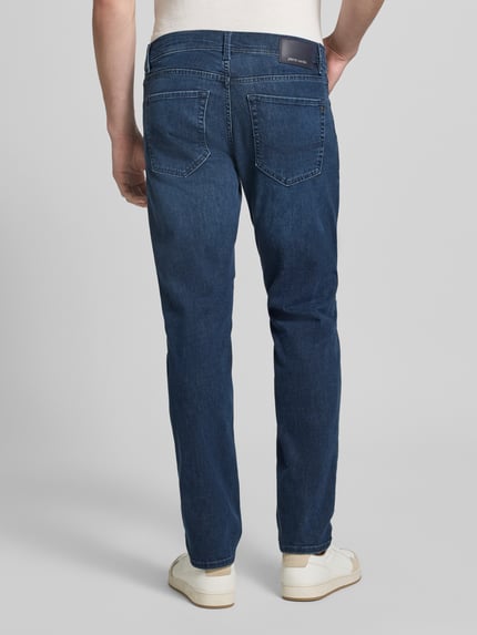 Männermodel trägt Jeans im Used-Look Modell 'Lyon' von Pierre Cardin, Baumwoll-Viskose-Mix, Regular-Fit, Rückansicht Ganzkörperansicht. Bundweite 42 cm, Innenbeinlänge 80 cm bei Größe 32/32.