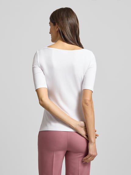 Frauenmodel trägt T-Shirt mit 1/2-Ärmel von comma, weißer Viskose-Elasthan-Mix, Slim Fit, U-Boot-Ausschnitt, Ganzkörperansicht Rückansicht.