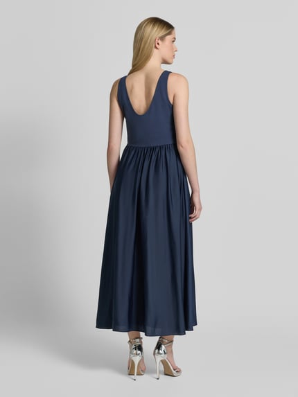 Modelka nosi Abendkleid mit Rückenausschnitt und breiten Trägern von Christian Berg Cocktail, granatowy, materiał z domieszką stretchu, fason A-linia, długość midi, szerokie ramiączka, głęboki dekolt na plecach, szerokość w rozmiarze 36: 40 cm, długość tyłu: 132 cm, widok całej sylwetki od tyłu.