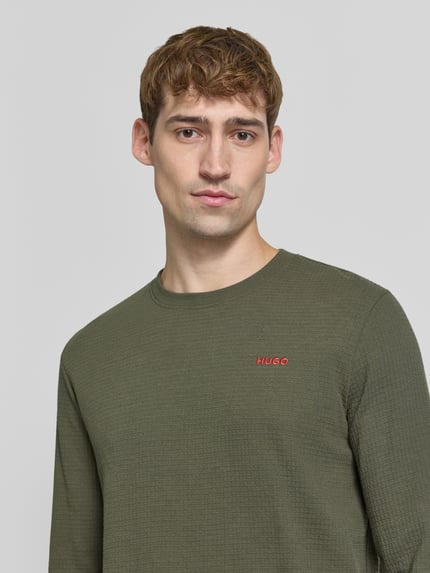 Männermodel trägt Regular Fit Pyjama aus katoenmix model 'Austin' van HUGO in olijfgroen met geribbelde textuur, Nahaufnahme Oberkörper, Heren pyjama van HUGO.