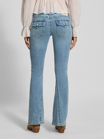 Vrouwenmodel draagt Low Rise Flared Jeans met steekzakken model 'JOEY' van TRUE RELIGION, lichtblauw, used-look, katoenmix, volledige achteraanzicht.