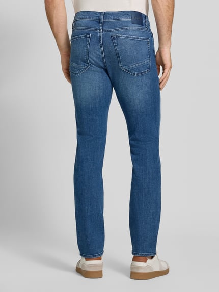 Mannenmodel draagt Modern Fit Jeans uit katoenmix Model 'Chuck' van Brax, denimlook, 5-pocketmodel, twill, mid waist, labelpatch, labeldetail, knoop- en ritssluiting, riemlussen, detailrijke textuur, kleur blauw, Ganzkörperansicht Rückansicht.