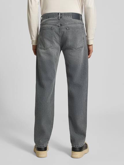 Männermodel trägt Bootcut Fit Jeans aus reiner Baumwolle von Closed, grauer Used-Look, 5-Pocket-Design, Ganzkörperansicht Rückansicht.