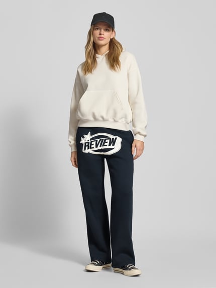 Frauenmodel trägt Straight Leg Sweatpants mit Logo und elastischem Bund von Review in Dunkelblau, Baumwoll-Mix, Ganzkörperansicht von vorne.