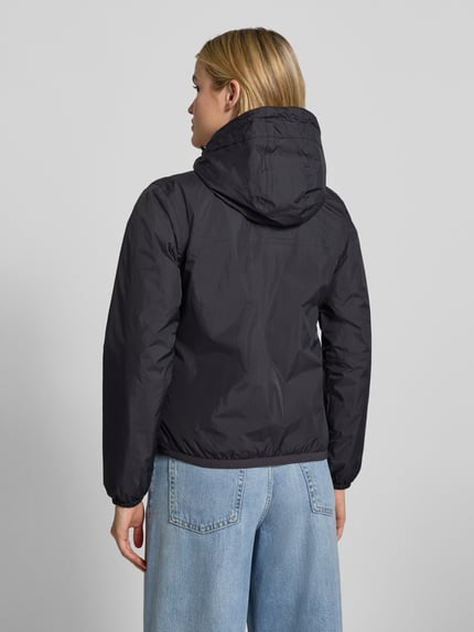 Frauenmodel trägt schwarze Regular Fit Jacke mit Logo-Print Modell 'CLAUDETTE' von K-WAY, elastische Abschlüsse, Ganzkörperansicht Rückansicht.