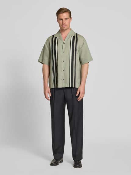 Männermodel trägt Relaxed Fit Freizeithemd aus Leinen-Lyocell-Mix Modell 'ESPINO' von HUGO, Mehrfarbig, Gestreift, Ganzkörperansicht von vorne.