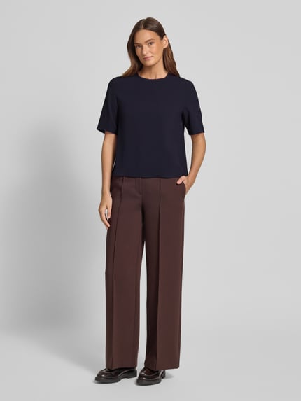 Frauenmodel trägt Regular Fit T-Shirt mit Rundhalsausschnitt von Windsor, Damen T-Shirt mit Fransenbesatz und Halbarm, Ganzkörperansicht von vorne. Rückenlänge 55 cm, Ärmellänge 28 cm bei Größe 36, dunkle Farben, glatte Textur.