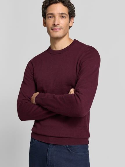 Männermodel trägt Strickpullover aus Baumwoll-Kaschmir-Mix mit Rundhalsausschnitt von MCNEAL in Bordeaux, Nahaufnahme Oberkörper, Regular Fit.