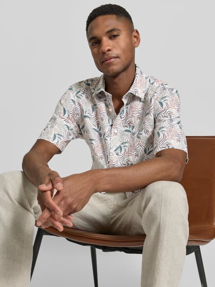 Männermodel trägt Slim Fit Business Hemd aus Leinen-Misch mit Kentkragen von Jake*s, florales Muster, Pastellfarben, Nahaufnahme Oberkörper.