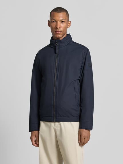 Mężczyzna nosi Regular Fit Steppjacke mit Stehkragen Modell 'LIGHT' von Strellson, ciemnoniebieska, gładka faktura, Ganzkörperansicht von vorne, kurtka pikowana męska marki Strellson.