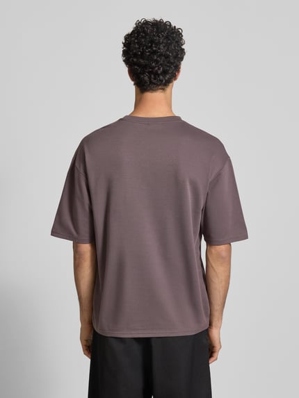 Männermodel trägt Boxy Fit T-Shirt aus Baumwoll-Mix Modell 'CASPIAN AIRFLEX BOXY' von Only & Sons, Optik: Unifarben, kühlend, atmungsaktiv, feuchtigkeitsregulierend, Ganzkörperansicht Rückansicht.