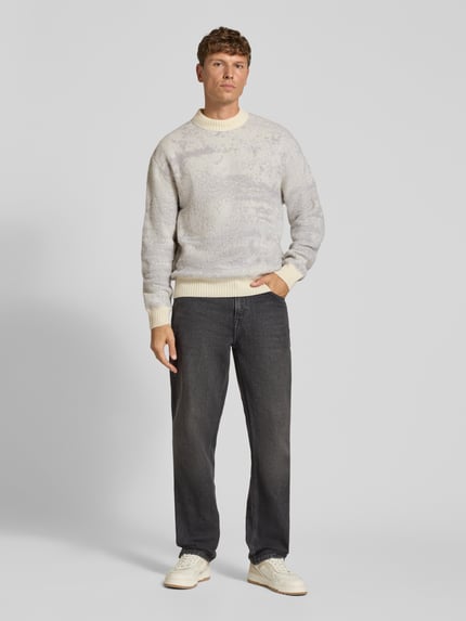 Männermodel trägt Pullover mit geripptem Rundhals Modell 'Kastet' von BOSS Orange, mehrfarbig, Strickoptik, Ganzkörperansicht von vorne.