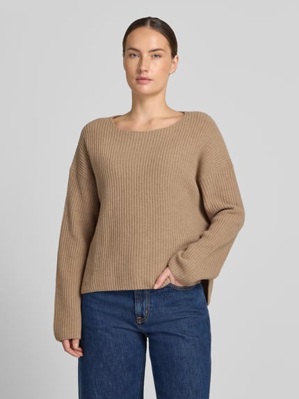 Frauenmodel trägt Relaxed Fit Pullover aus Schurwoll-Mix von Marc O'Polo in Beige mit breiter Rippenstruktur, kombiniert mit blauer Jeans, Ganzkörperansicht von vorne. Damen Pullover von Marc O'Polo.