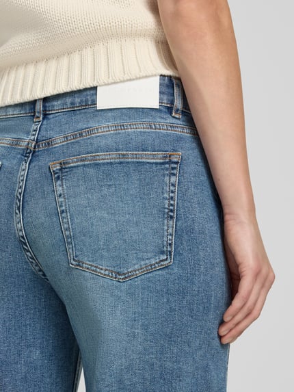 Kobiece model nosi Curved Barrel Jeans aus Baumwoll-Mix Modell 'Meni moon' von OPUS PANTS, niebieski denim, detal tylnej kieszeni, zbliżenie pleców.