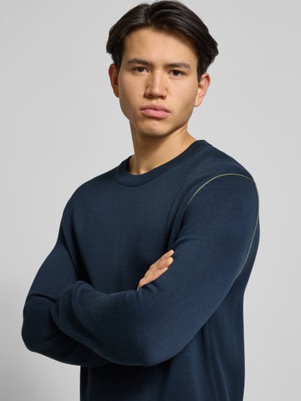 Männermodel trägt Regular Fit Strickpullover aus Baumwoll-Mix von Marc O'Polo Denim in Unifarbe, Rundhals, Langarm, Nahaufnahme Oberkörper.