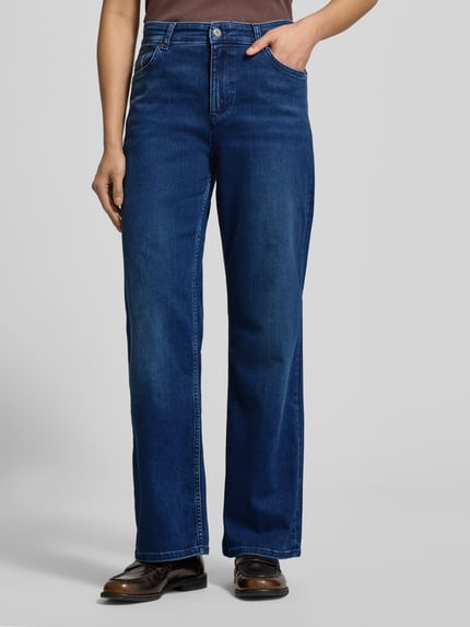 Frauenmodel trägt Loose Fit Jeans mit 5-Pocket-Design Modell 'Madison' von Mustang, Baumwoll-Lyocell-Mix mit Stretch-Anteil, lockerer Schnitt, Knopf- und Reißverschluss, Bundweite 37 cm, Innenbeinlänge 77 cm, klassische blaue Farbe, dezente Waschung, glatte Textur, Ganzkörperansicht von vorne.