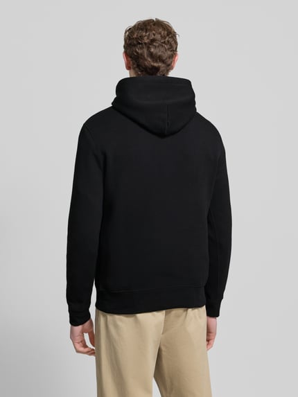 Männermodel draagt Hoodie met labelprint van Polo Ralph Lauren in zwart, katoenmix, los model, capuchon, ribboorden, ruglengte maat M 67 cm, mouwlengte maat M 65 cm. Ganzkörperansicht Rückansicht.
