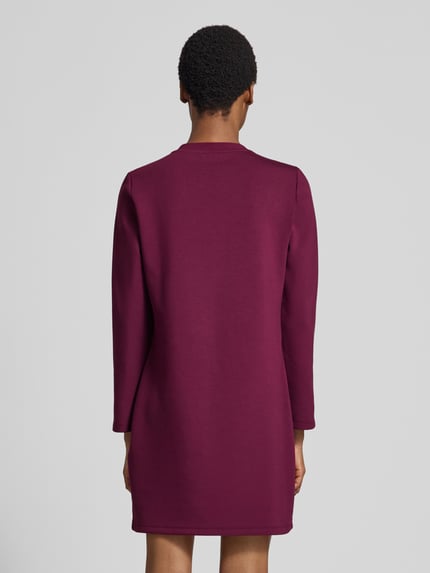 Frauenmodel trägt Regular Fit Minikleid aus Viskose-Mix Modell 'Abito' von Liu Jo in Dunkelrot, langärmelig, Rückenansicht, Detailangaben: Ziersteinbesatz, Serafino-Ausschnitt, elastische Qualität, Rückenlänge 88 cm, Brustweite 50 cm, Ärmellänge 61 cm. Ganzkörperansicht Rückansicht.