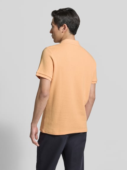 Männermodel trägt Regular Fit Strick-Poloshirt mit V-Ausschnitt von MCNEAL in Pfirsich, Struktur Baumwoll-Mix mit Stretch-Anteil, Ganzkörperansicht Rückansicht. Rückenlänge bei Größe M: 70 cm.