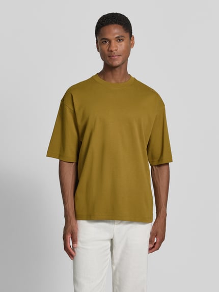 Męski model trägt Relaxed Fit T-Shirt mit Rundhalsausschnitt von JAKE*S STUDIO MEN z bawełny, kolor oliwkowy, krótki rękaw, długość tyłu w rozmiarze M 67 cm, Ganzkörperansicht von vorne.