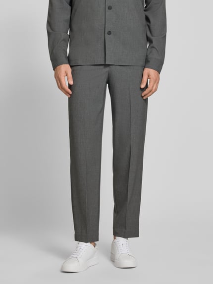 Männermodel trägt Slim Fit Stoffhose mit Viskose-Anteil von Lindbergh in Grau, mit Bügelfalte und Eingrifftaschen, Ganzkörperansicht von vorne.