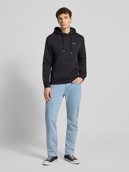 Männermodel trägt Straight Fit Jeans aus Baumwoll-Mix Modell 'CASH' von Pepe Jeans in hellblauer Melange-Optik, Ganzkörperansicht von vorne.