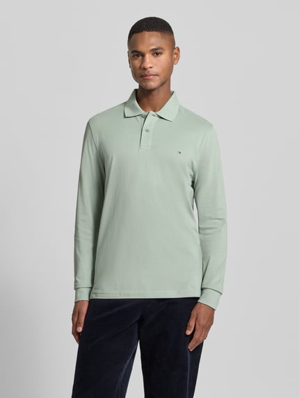 Männermodel trägt Poloshirt mit Label-Stitching von Christian Berg Men in Mintgrün aus reiner Baumwolle, Slim-Fit, Ganzkörperansicht von vorne.