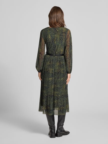 Frauenmodel trägt Midikleid aus Viskose-Mix Modell 'Sabia' von ZABAIONE in Grün mit langen Ärmeln, taillierte Passform, Ganzkörperansicht Rückansicht.