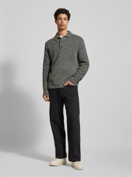 Männermodel trägt Strickpullover aus Woll-Mix mit Polokragen von Calvin Klein Jeans, Regular-Fit, Knopfleiste, Label-Detail, Ganzkörperansicht von vorne.