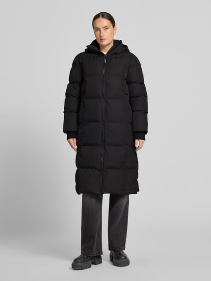 Vrouwenmodel draagt zwarte lange jas met capuchon, tweewegritssluiting, steekzakken, Cars Jeans Model 'HEMCIA', recht model, Ganzkörperansicht von vorne.