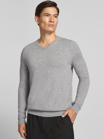 Männermodel trägt gebreide pullover van kasjmier met v-hals van Christian Berg Men in regular fit, ruglengte maat M 71 cm, mouwlengte maat M 71 cm, grijs, zachte textuur, volledige lichaamsweergave van voren.